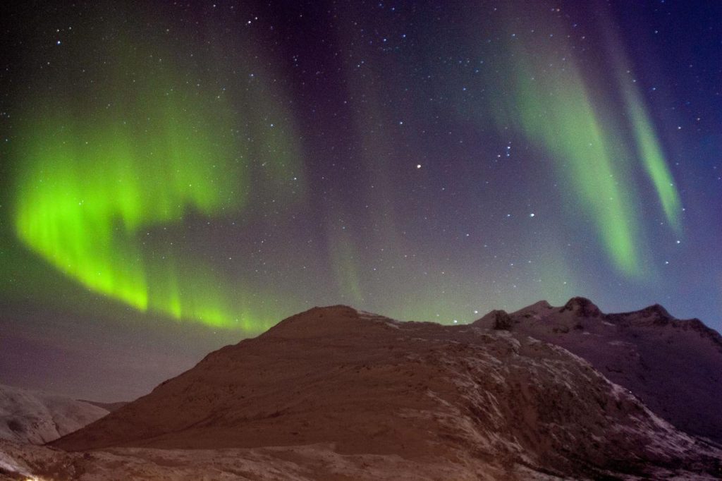 Aurore boréale au-dessus des montagnes près de Tromsø
