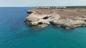 Grotta della Poesia et côte rocheuse de Roca Vecchia vues par drone