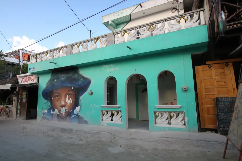 Fresque peinte sur une façade verte dans le village de Holbox